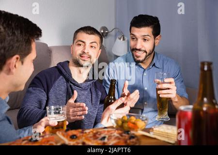 Friendly meeting in men company over beer with pizza Stock Photo