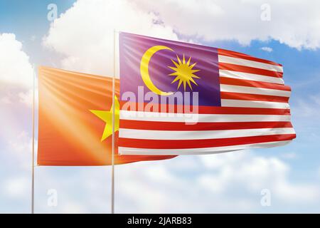 Sunny blue sky and flags of malaysia and vietnam Stock Photo