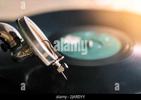 needle of an old portable gramophone with a powder-covered vinyl record Stock Photo