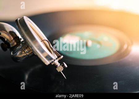 needle of an old portable gramophone with a powder-covered vinyl record Stock Photo