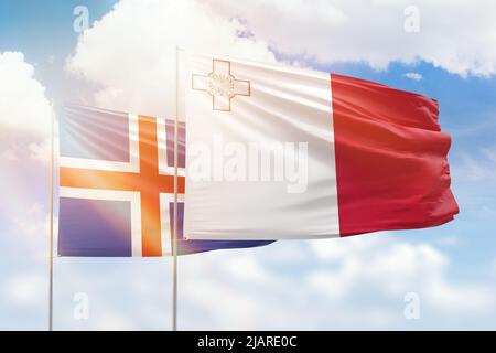 Sunny blue sky and flags of malta and iceland Stock Photo