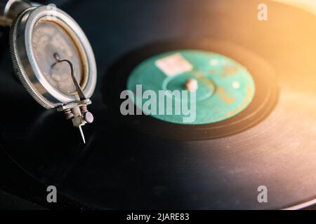 needle of an old portable gramophone with a powder-covered vinyl record Stock Photo