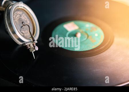 needle of an old portable gramophone with a powder-covered vinyl record Stock Photo