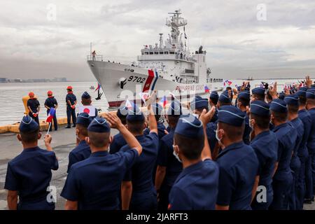 Manila, Philippines. 1st June, 2022. Members of the Philippine Coast Guard wave Philippine and Japanese flags as they welcome the arrival of the BRP Melchora Aquino at Manila's port area, Philippines. June 1, 2022. The brand new multi-role vessel built by Japan was ordered by the coast guard to strengthen its maritime security, safety and marine environmental protection capabilities in the country's waters, especially in the disputed South China Sea where the Philippines continues to have tense territorial standoffs with China. (Credit Image: © Basilio Sepe/ZUMA Press Wire) Stock Photo