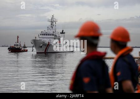 Manila, Philippines. 1st June, 2022. Workers watch as members of the Philippine Coast Guard welcome the arrival of the BRP Melchora Aquino at Manila's port area, Philippines. June 1, 2022. The brand new multi-role vessel built by Japan was ordered by the coast guard to strengthen its maritime security, safety and marine environmental protection capabilities in the country's waters, especially in the disputed South China Sea where the Philippines continues to have tense territorial standoffs with China. (Credit Image: © Basilio Sepe/ZUMA Press Wire) Stock Photo