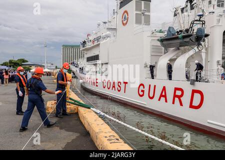 Manila, Philippines. 1st June, 2022. Workers secure ropes while sailors stand on deck manning the rail as BRP Melchora Aquino prepares to dock at Manila's port area, Philippines. June 1, 2022. The brand new multi-role vessel built by Japan was ordered by the Philippine Coast Guard to strengthen its maritime security, safety and marine environmental protection capabilities in the country's waters, especially in the disputed South China Sea where the Philippines continues to have tense territorial standoffs with China. (Credit Image: © Basilio Sepe/ZUMA Press Wire) Stock Photo