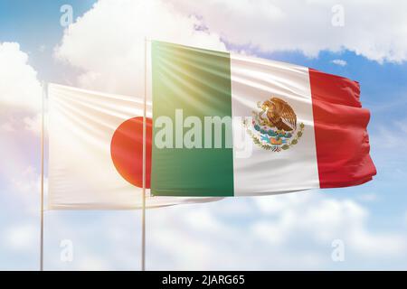 Sunny blue sky and flags of mexico and japan Stock Photo