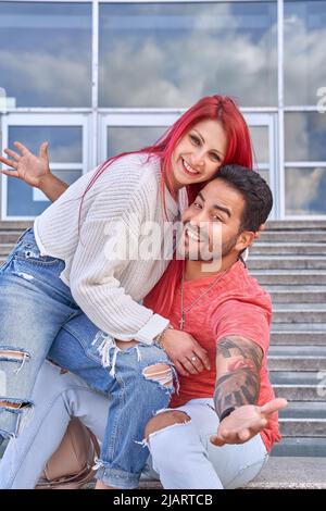 Happy bride and groom sitting on a staircase looking at the camera. Relationship concept  Stock Photo