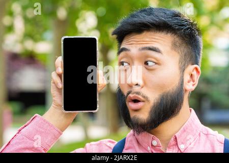 Man with a surprised face showing the screen of mobile Stock Photo