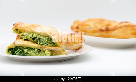 Fresh baked golden flaky spinach and feta pastie Stock Photo