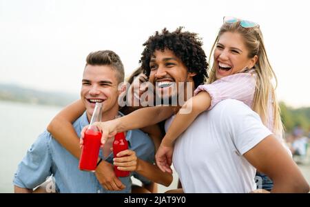 Friends having fun together at the beach and drinking a cold beer Stock Photo