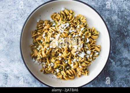 vegan spinach and dairy-free ricotta pasta bowl with wholemeal spirals, healthy plant-based food recipes Stock Photo