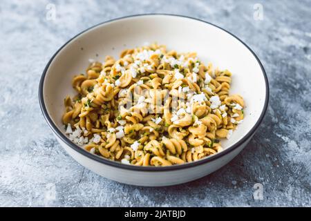 vegan spinach and dairy-free ricotta pasta bowl with wholemeal spirals, healthy plant-based food recipes Stock Photo