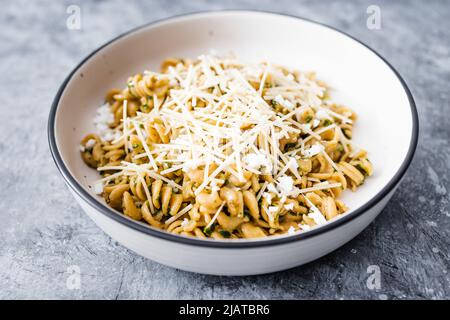 vegan spinach and dairy-free cheese pasta bowl with wholemeal spirals, healthy plant-based food recipes Stock Photo