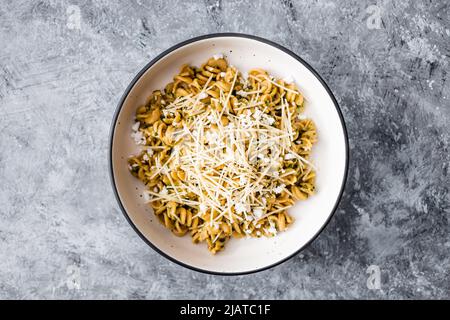 vegan spinach and dairy-free cheese pasta bowl with wholemeal spirals, healthy plant-based food recipes Stock Photo