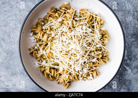 vegan spinach and dairy-free cheese pasta bowl with wholemeal spirals, healthy plant-based food recipes Stock Photo