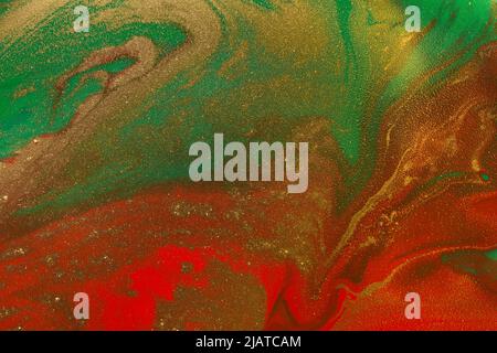 Gold waves on flow red and green paints abstract background. Stock Photo