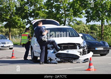 Munich, Deutschland. 01st June, 2022. Police officers at the accident recording after a traffic accident. Car accident, a battered car with front damage is after an accident at an intersection accident, accident car, damage, body damage, dent, dents Credit: dpa/Alamy Live News Stock Photo