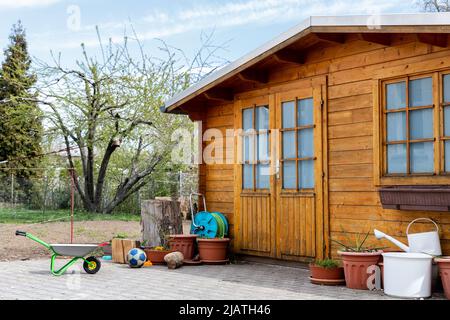Small beautiful wooden house shed or storage hut for garden tools equipment and bicycles at backyard at beautiful american or european countryside bac Stock Photo
