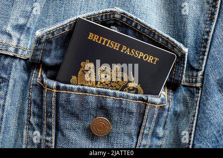 new british passport in blue denim jacket pocket Stock Photo