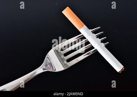 cigarette fork dinner fork with cigarette Stock Photo