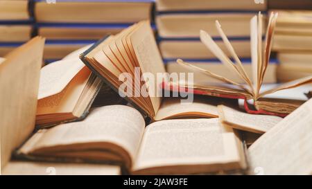 Many open ancient books on the table. 19th century books close up with selective focus. Toned i,age Stock Photo