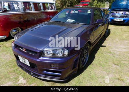 Three-quarters front view of a Purple, 2000, Nissan R34 Skyline GT-T Coupe on display at the Deal Classic Car Show 2022 Stock Photo