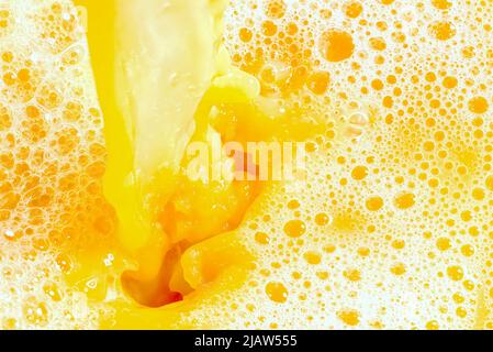 Closeup of splashing orange juice, top view. Splash of fresh sweet orange, mango, fruit juice. Stock Photo