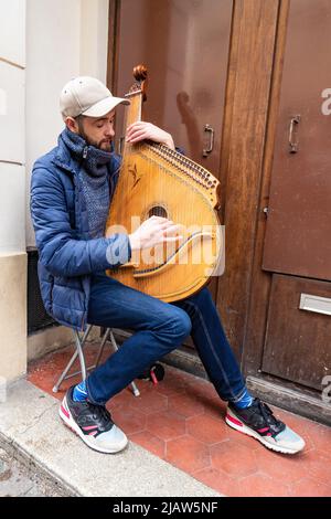 Paris, France - March 17, 2018:  Musician playing a zither aroa in the streets of Montmartre in Paris, France Stock Photo