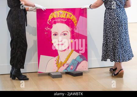 London, UK.  1 June 2022.  Staff members present Andy Warhol’s “Queen Elizabeth II of the United Kingdom”, 1985, at Phillips, Berkeley Square gallery.  The work is to be auctioned with an estimate of £100,000 – 150,000.  This year marks the Platinum Jubilee of the Queen’s reign.  Credit: Stephen Chung / Alamy Live News Stock Photo