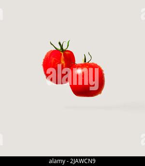 Red, ripe, fresh and tasty tomato sliced on grey background. Minimal food concept. Stock Photo