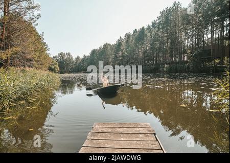 Joyous blonde woman sitting in the boat Stock Photo