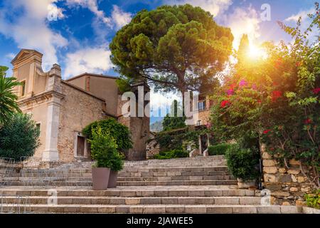 Beautiful old town of Taormina with small streets, flowers. Architecture with archs and old pavement in Taormina. Colorful narrow street in old town o Stock Photo