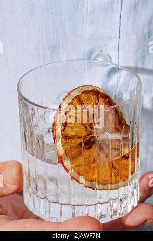 Gin tonic cocktail garnished with  burnt orange slice Stock Photo