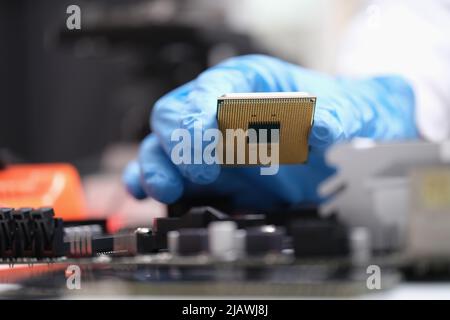 Engineer holds in hands powerful processor or board after repair Stock Photo