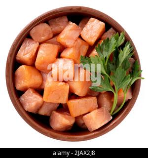 Salmon cut into small cubes in a bowl isolated on a white background, top view Stock Photo