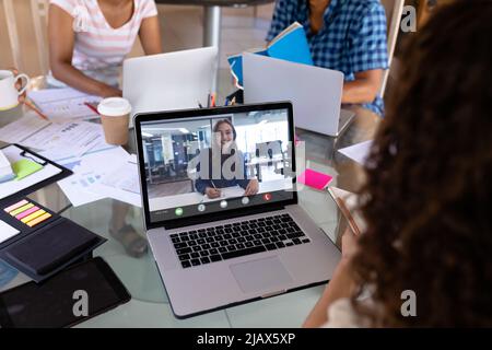 Female coworkers discussing work while having online meeting in office Stock Photo