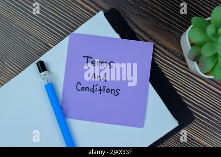 Concept of Terms and Conditions write on sticky notes isolated on Wooden Table. Stock Photo