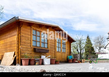 Small beautiful wooden house shed or storage hut for garden tools equipment and bicycles at backyard at beautiful american or european countryside Stock Photo