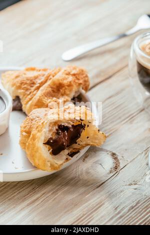 Plate with chocolate croissants on a light wooden surface sured with Stock Photo