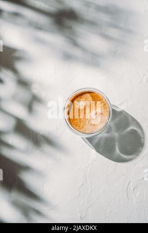 Cup of coffee on white table with beautiful shadows Stock Photo