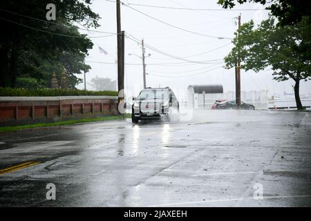 Stock photos of Tropical Storm Elsa from 2021 drenching Newport, Rhode Island. Cars drive through flood waters at the entrance to Aquidneck Island. Stock Photo