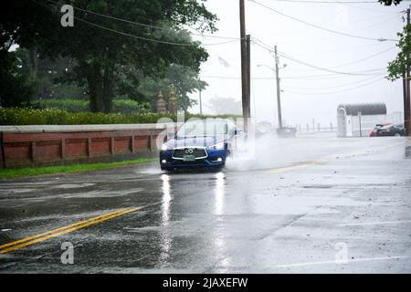 Stock photos of Tropical Storm Elsa from 2021 drenching Newport, Rhode Island. Cars drive through flood waters at the entrance to Aquidneck Island. Stock Photo