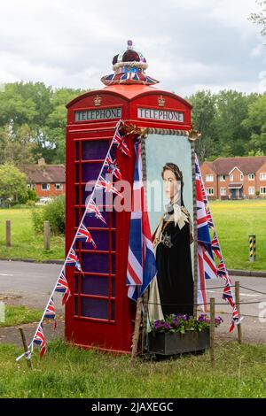 Red phone box decorated for the Queens Platinum Jubilee in the Surrey village of Compton, England, UK Stock Photo