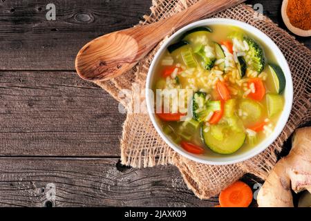Healthy vegetable soup with turmeric and ginger. Top view table scene on a rustic dark wood background. Stock Photo