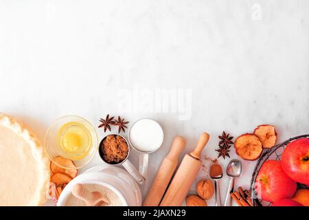 Fall baking bottom border with apple pie ingredients. Top view over a white marble background with copy space. Stock Photo