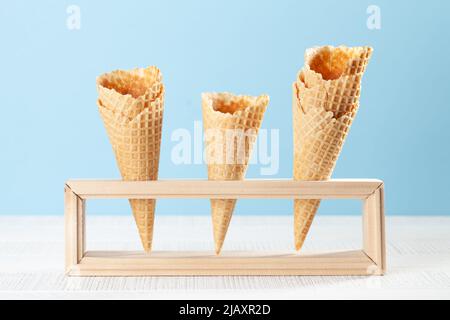 Empty ice cream waffle cones in wooden stand Stock Photo