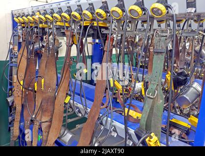 Multiple coal miners lamps on belts charging batteries, lamp room in a South Wales pit colliery Stock Photo