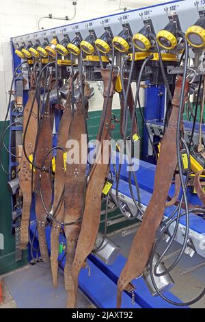 Multiple coal miners lamps on belts charging batteries, lamp room in a South Wales pit colliery Stock Photo