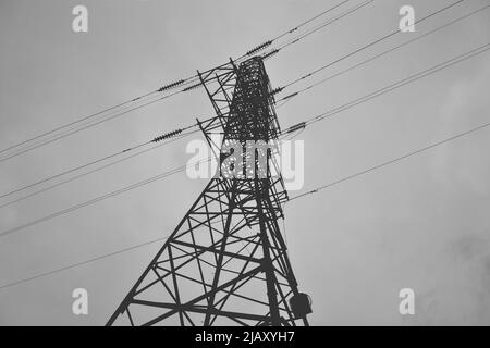 Black and white photo of power lines against a cloudy sky Stock Photo